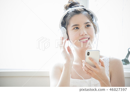 A woman listening to music with headphones 46827397