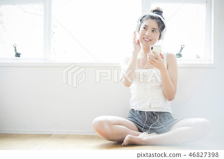 A woman listening to music with headphones 46827398