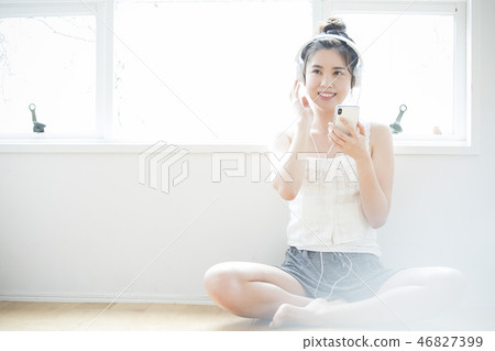 A woman listening to music with headphones 46827399