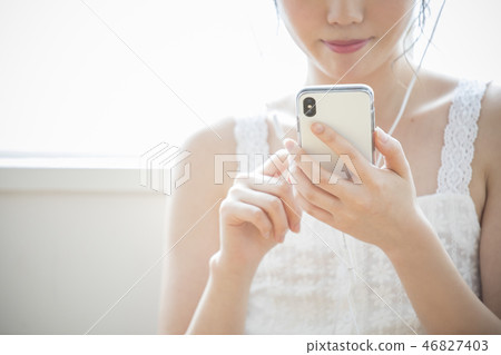 A woman listening to music with headphones 46827403