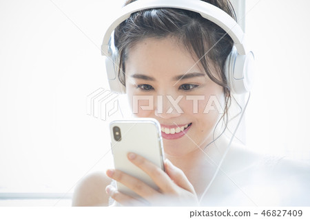 A woman listening to music with headphones 46827409