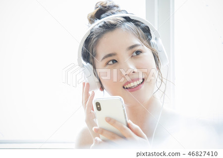A woman listening to music with headphones 46827410