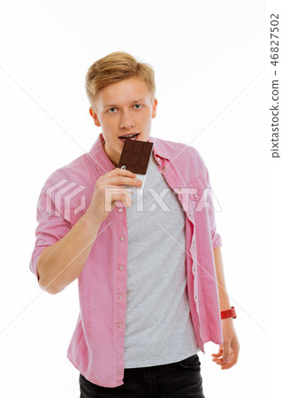 Pleasant cheerful man holding a bar of chocolate Pleasant cheerful man holding a bar of chocolate 46827502