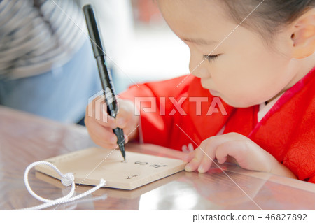 Girl writing a wish on a ema in a kimono Girl writing a wish on a ema in a kimono 46827892