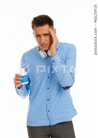 Cheerless nice young man touching his forehead Cheerless nice young man touching his forehead 46828416