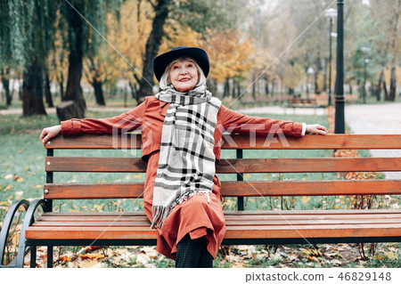 Pleased elegant woman enjoying autumn weather in park 46829148