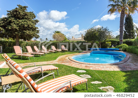 Sun beds and mattresses, near the luxury pool for relaxing. 46829452