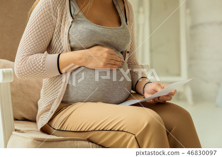Pregnant woman checking her medical examinations results 46830097