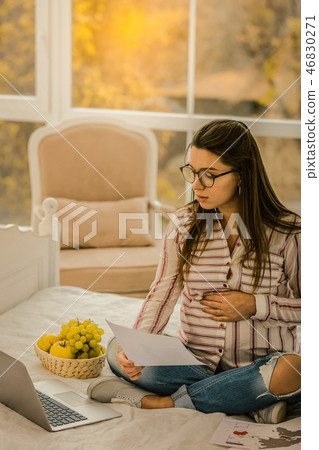 Woman concentratedly learning foreign languages while pregnancy 46830271