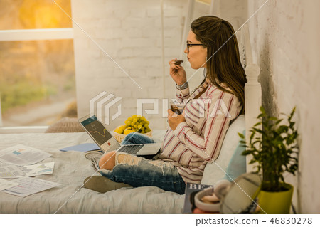Pregnant woman working at home and eating a dessert Pregnant woman working at home and eating a dessert 46830278