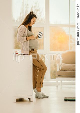Pregnant woman staying at home and drinking tea 46830316