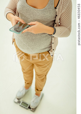 Pregnant woman using mobile app for controlling her weight 46830458