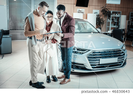Bearded car consultant giving documents for his clients Bearded car consultant giving documents for his clients 46830643