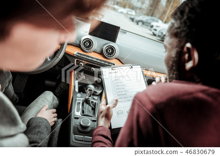 Bearded instructor putting marks for the first section of test driving Bearded instructor putting marks for the first section of test driving 46830679