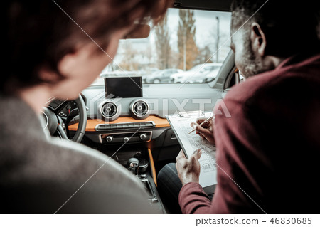 Close up of dark-haired student getting his marks for test driving Close up of dark-haired student getting his marks for test driving 46830685