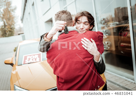 Handsome young son feeling extremely happy after receiving car Handsome young son feeling extremely happy after receiving car 46831041