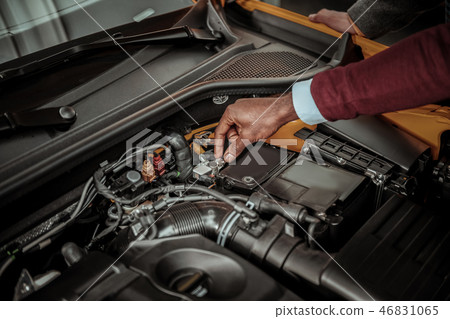 Sales manager of car salon opening front trunk and showing engine 46831065