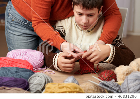 Mother is learning her child boy to knit. Mother is learning her child boy to knit. 46831296