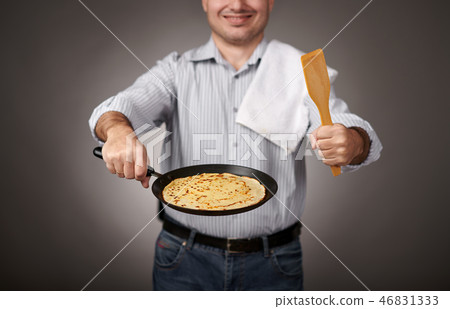 man posing with a pancake in a pan, white shirt  46831333