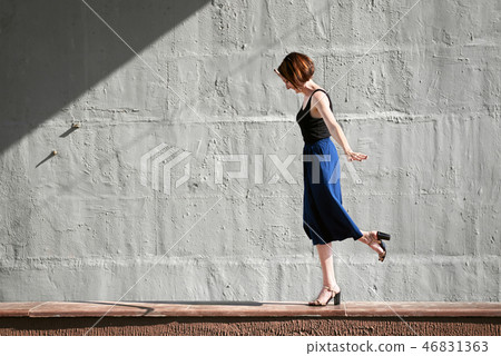 young girl posing against a concrete wall 46831363