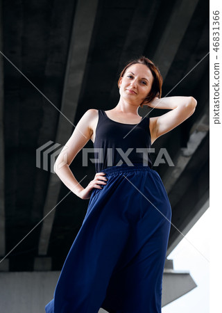 young girl posing against a concrete wall 46831366