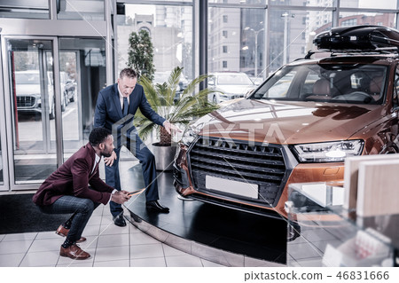 Businessman wearing dark costume buying big family car Businessman wearing dark costume buying big family car 46831666