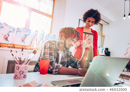 Cheerful stylish girlfriend helping her man working on interior design Cheerful stylish girlfriend helping her man working on interior design 46832000