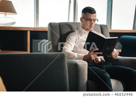 Smart young man wearing glasses reading the Holy Bible 46832446