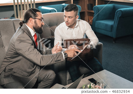 Bearded dark-haired business partner giving his opinion on the situation Bearded dark-haired business partner giving his opinion on the situation 46832934