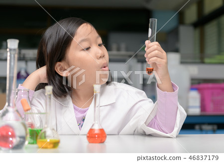 Happy little scientist in lab coat making experiment Happy little scientist in lab coat making experiment 46837179