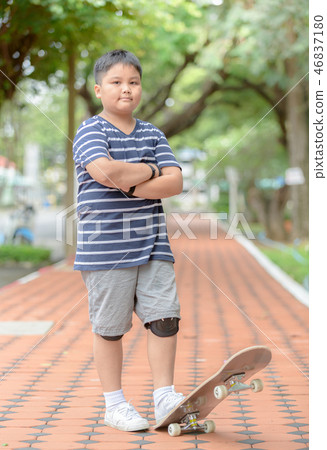 Obese boy stand on skate board Obese boy stand on skate board 46837180