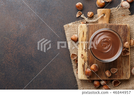 Chocolate spread with hazelnuts on brown countertop Chocolate spread with hazelnuts on brown countertop 46844957