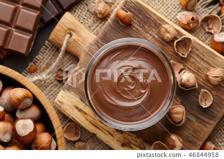 Chocolate spread, nuts and chocolate bars on table 46844958