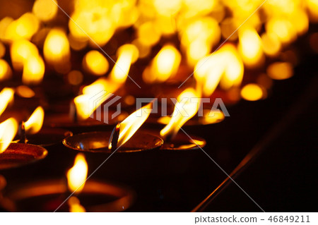 Many candle flames glowing in the dark 46849211