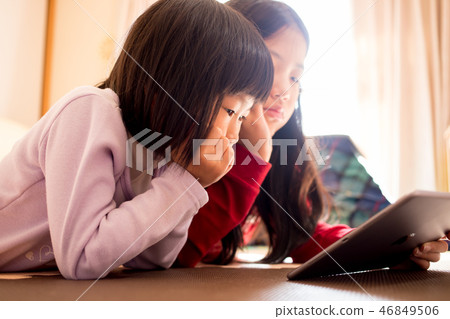 Children watching a tablet in the living room of the house Children watching a tablet in the living room of the house 46849506