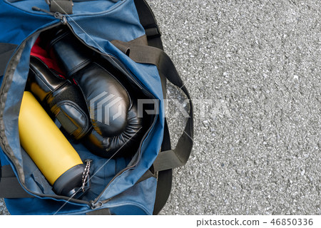 Sports bag and boxing gloves with water at the asphalt background Sports bag and boxing gloves with water at the asphalt background 46850336