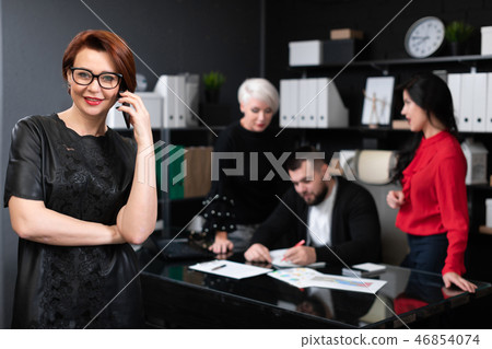 Businesswoman talking on phone on background of Office workers discussing project 46854074