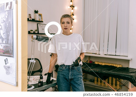 Good-looking tattoo master wearing plain white t-shirt and protective rubber gloves Good-looking tattoo master wearing plain white t-shirt and protective rubber gloves 46854159