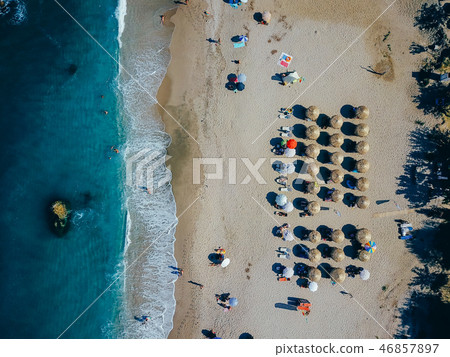 Beach with sun loungers on the coast of the ocean Beach with sun loungers on the coast of the ocean 46857897