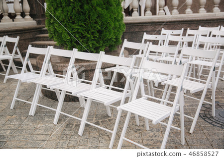 White chair on wedding ceremony. summer wedding decoration outside White chair on wedding ceremony. summer wedding decoration outside 46858527