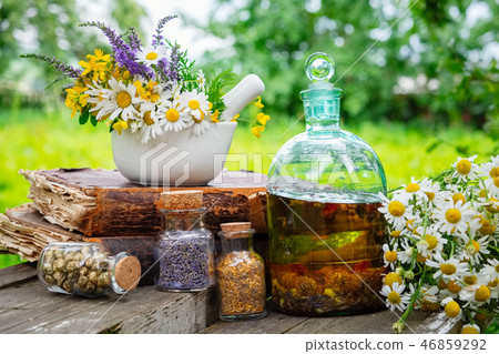 Mortar of herbs, essential oil bottle, old book. 46859292