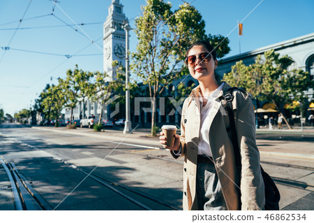 female holding coffee walking crossing railway 46862534