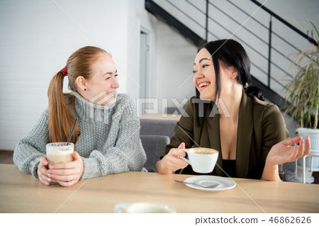 Two smiling students having a cup of coffee in college canteen 46862626