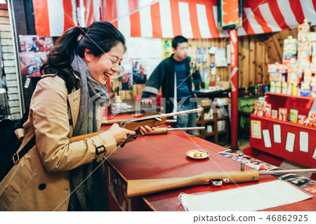 woman laughing playing shooting game in festival 46862925