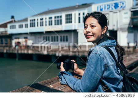 photographer holding slr camera on port 46862989