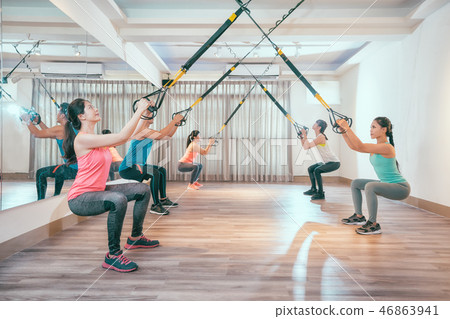 asian people doing squat with fitness straps 46863941