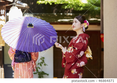 Two women in kimonos standing in front of the teahouse 46864871