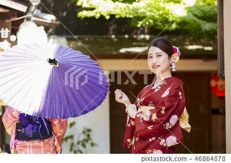 Two women in kimonos standing in front of the teahouse 46864878