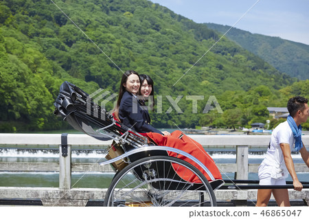 Two high school girls riding a rickshaw on the bridge 46865047