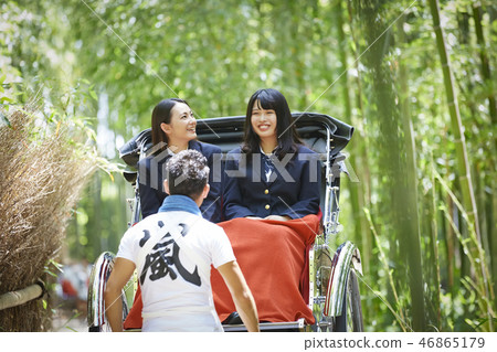 Two high school girls riding a rickshaw looking over Takebayashi Two high school girls riding a rickshaw looking over Takebayashi 46865179
